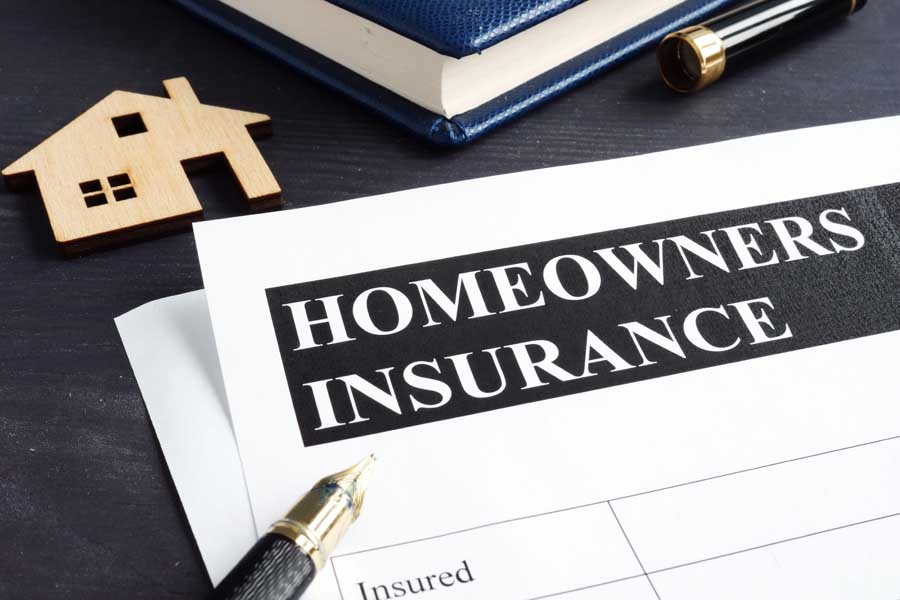 Homeowners insurance policy and model of home.
