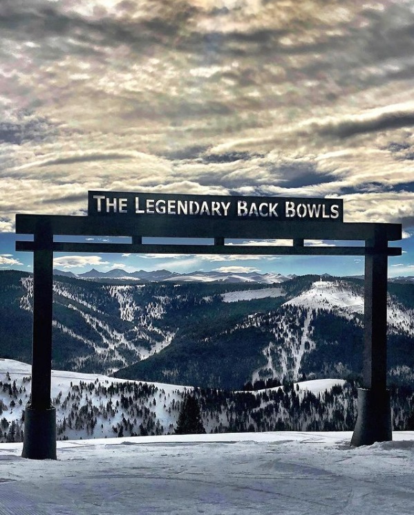 Signpost for The Legendary Back Bowls overlooking the mountains of Vail, CO