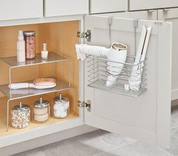 A wire rack being used for storage on a bathroom cabinet door