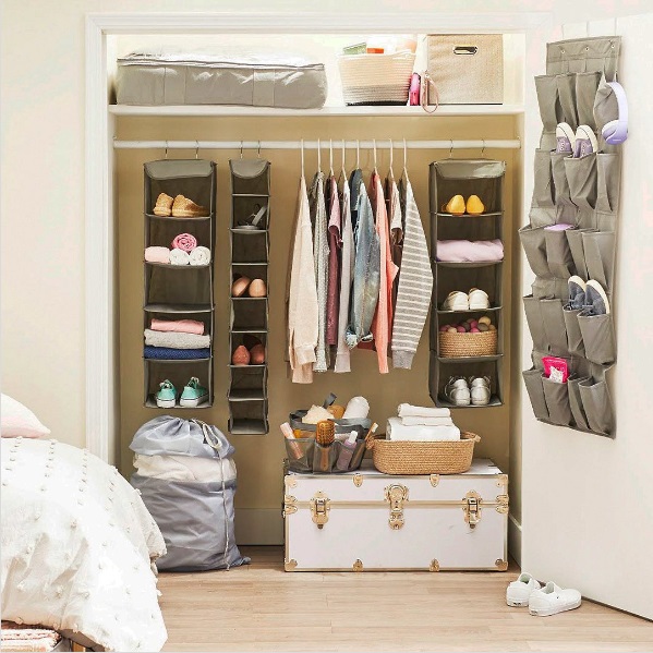 Image of a very organized closet with multiple hanging racks, baskets, and bins