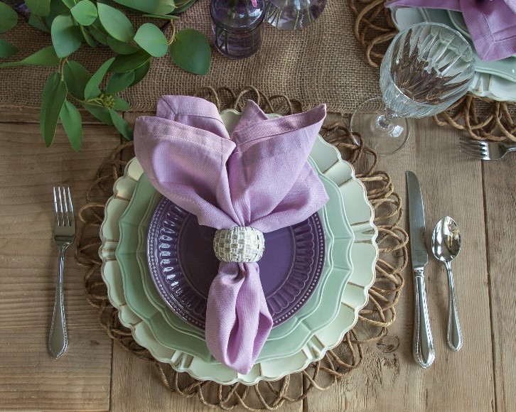 Dining room table setting including sage plates and lilac napkins. Add Very Peri for a pop of color