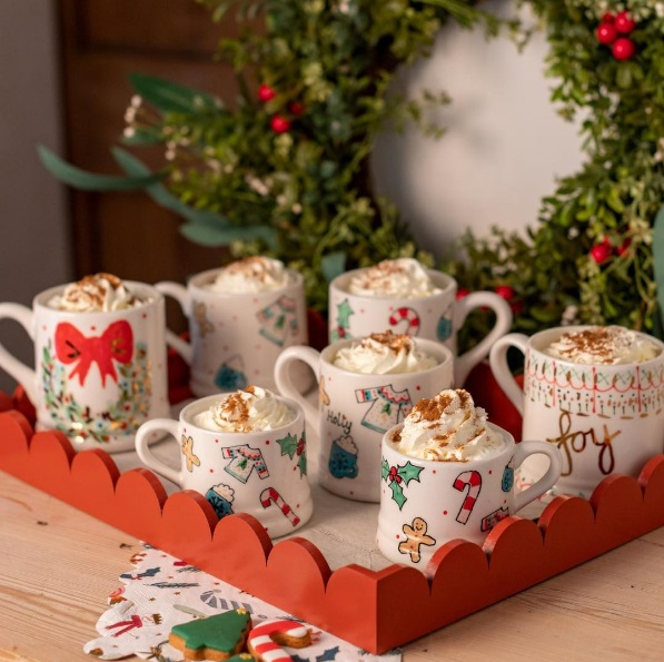 Tray of cute holiday-themed mugs of hot chocolate