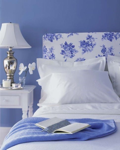Blue and white floral headboard with white bedding. Add Very Peri for more purple in the room.