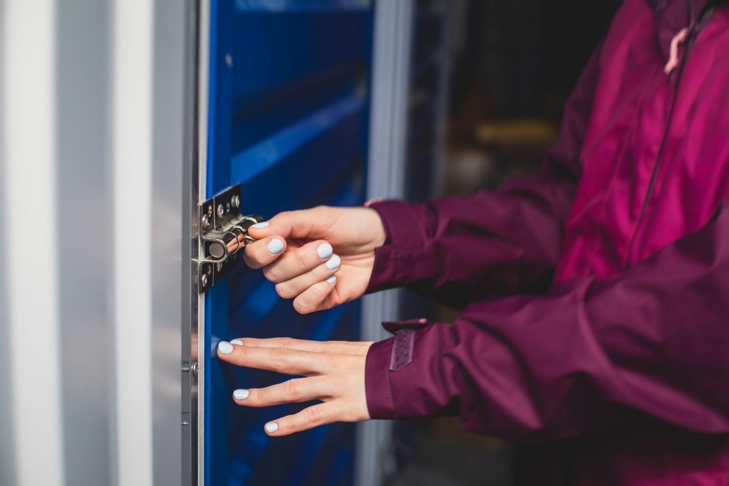 Close up of person's hands as they are unlocking a storage unit door
