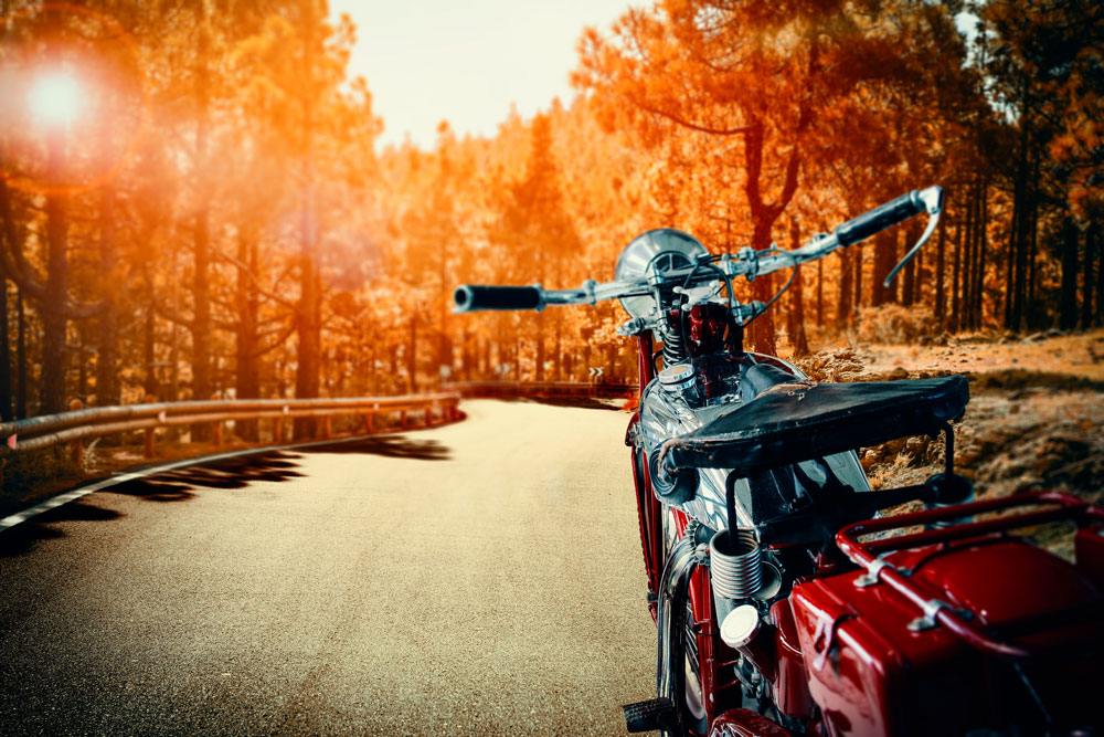 Motorcycle facing down a winding autumn road