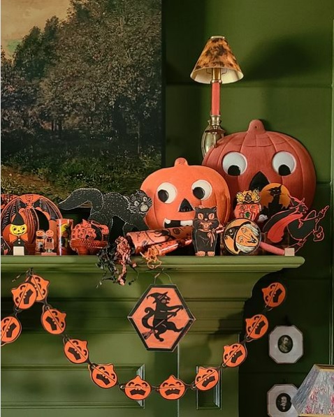A fireplace mantle covered in vintage Halloween decorations
