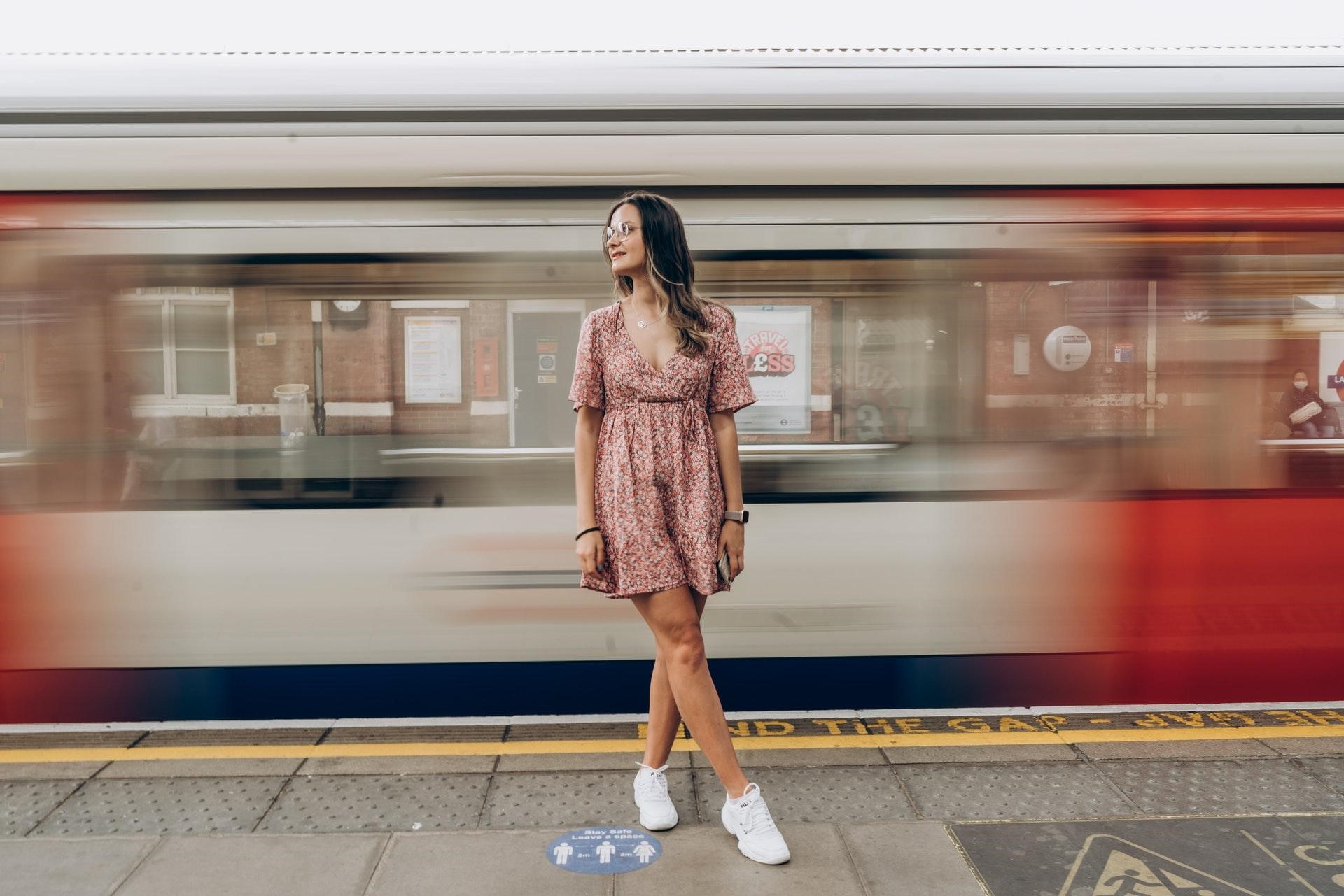Woman standing in front of a train