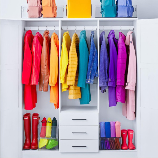A vibrant closet organized by color of the rainbow