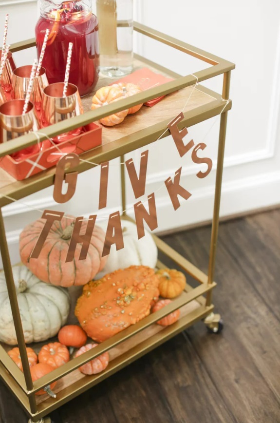 Fall-themed bar cart with pumpkins and a banner that says Give Thanks.