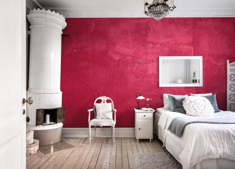 A white bedroom set laid against a magenta accent wall.