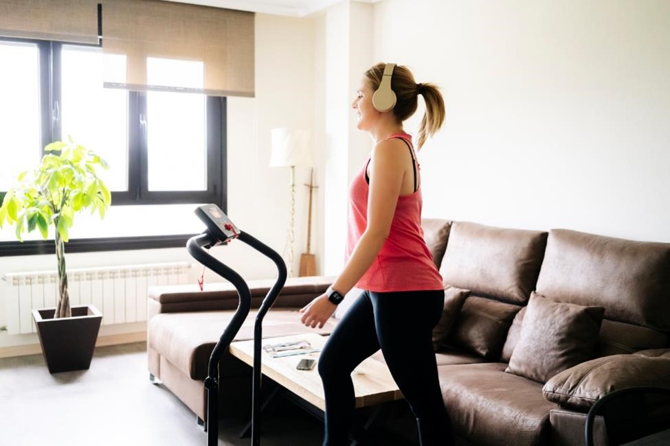A woman walking on a treadmill in her home gym