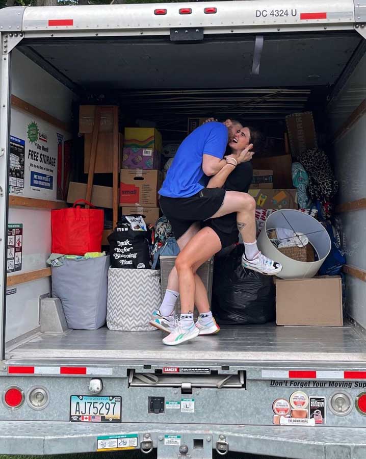 Couple holding each other in a moving truck, celebrating!