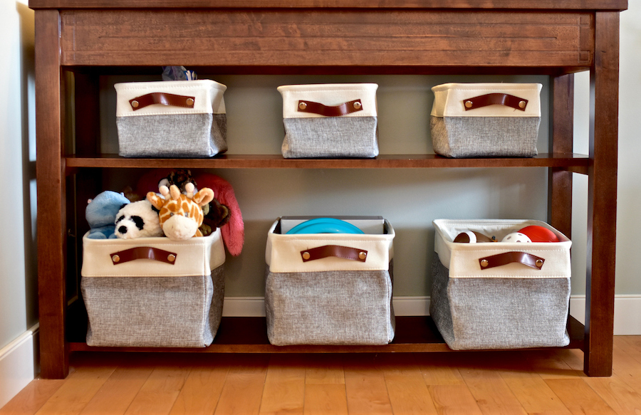 fabric bins filled with toys, including stuffed animals, sports balls, and other items