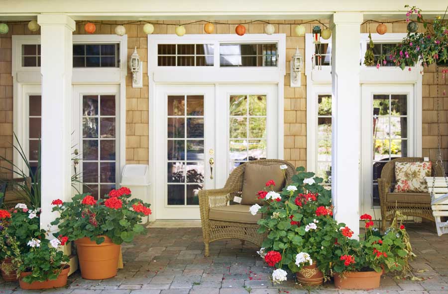 Cozy patio with plenty of fresh red and white flowers.