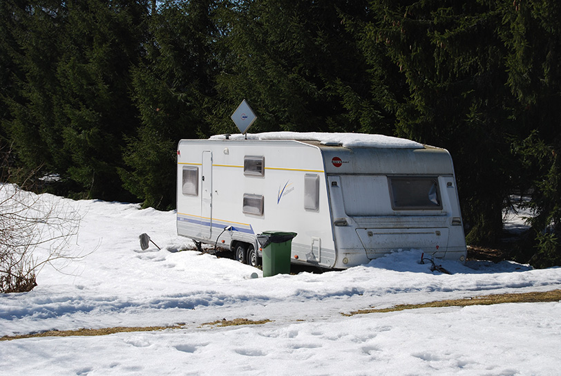 An uncovered camper parked in the snow