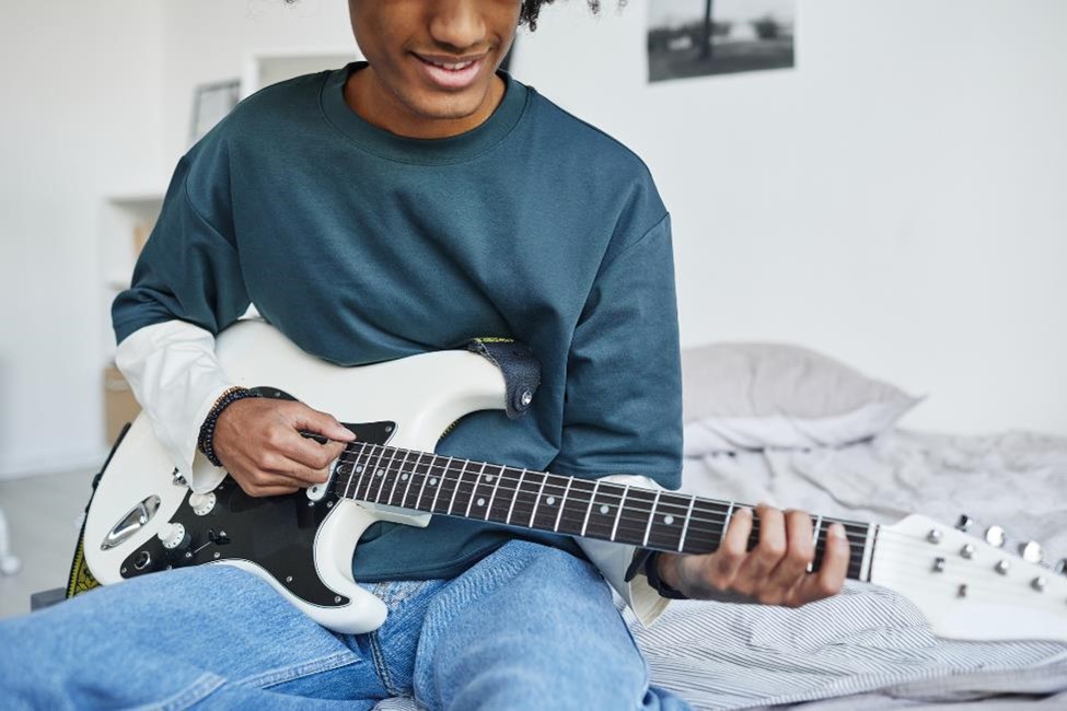 A young man playing an electric guitar