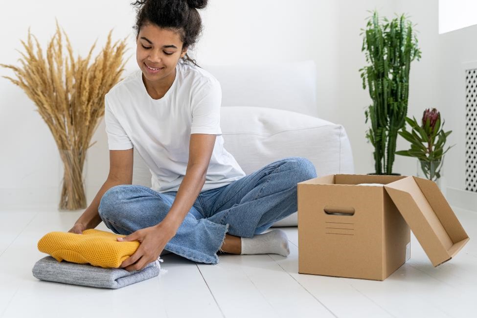 A young woman packing clothes