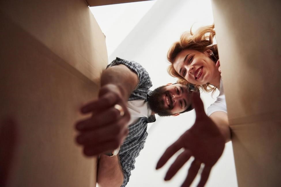 Two people reaching into a box