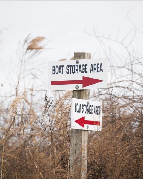 Signpost with arrows pointing toward boat storage
