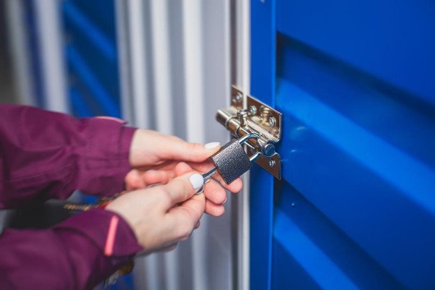 A pair of hands unlocking a storage unit door