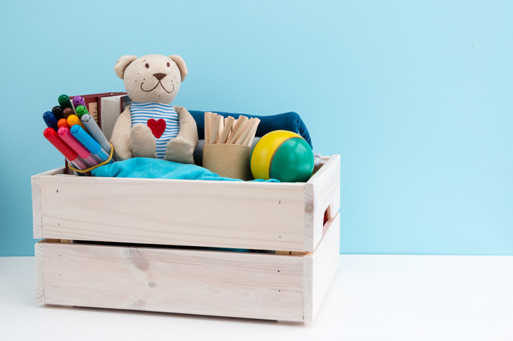 wooden box filled with toys and materials to be donated