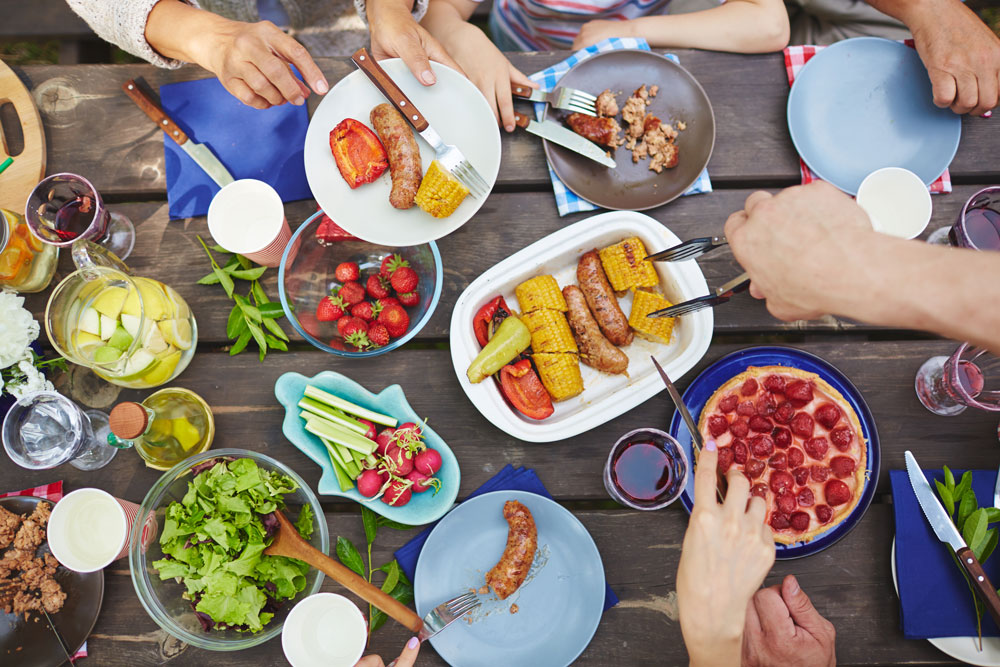 Above view of a family plating food at an outdoor picnic