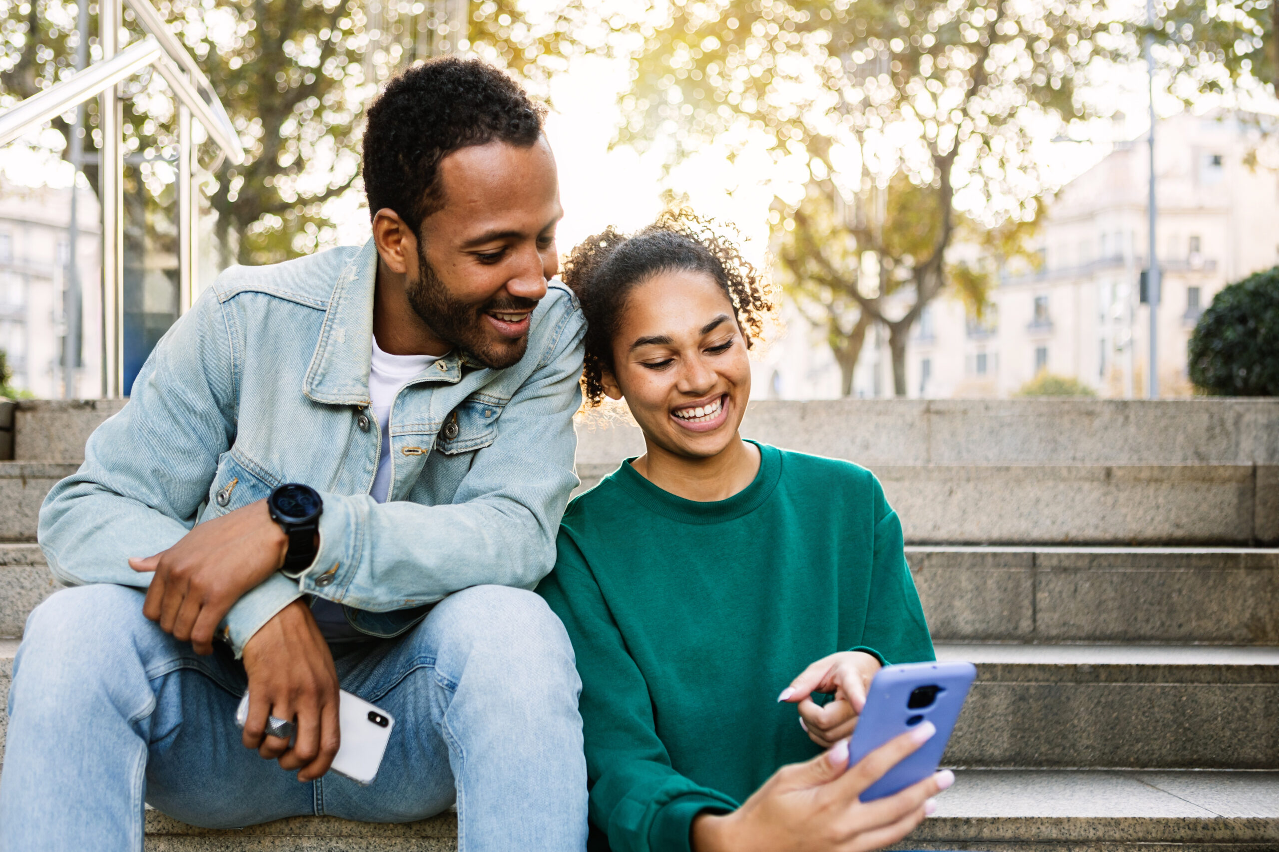 Two friends sitting together looking at a cell phone