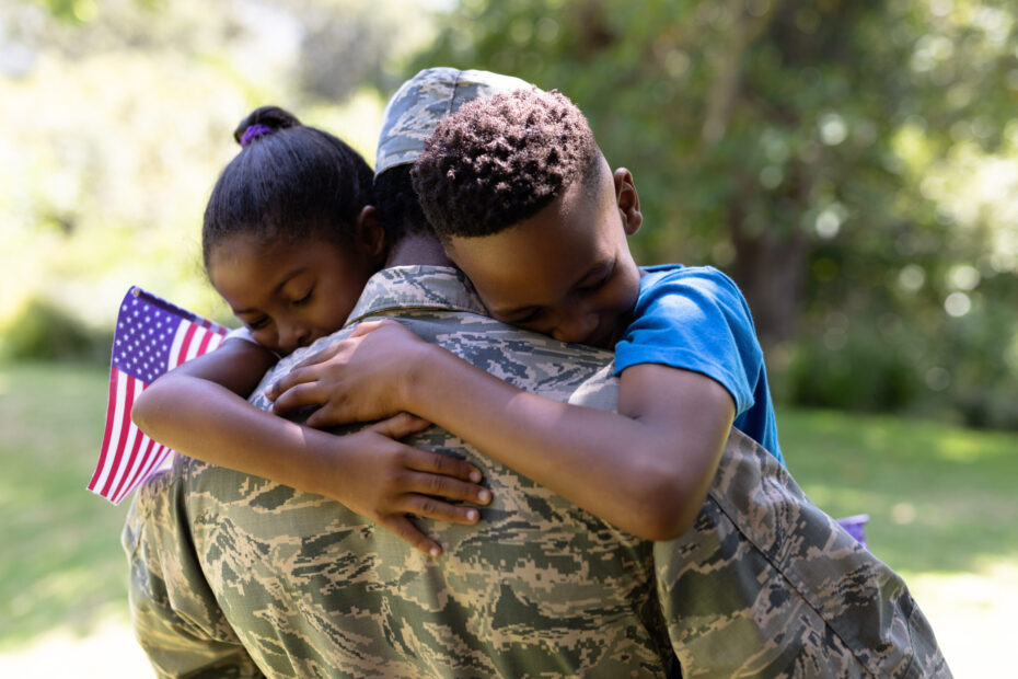Prime Storage honors veterans — military service member in uniform hugging two children holding an American flag, symbolizing family, gratitude, and Veterans Day appreciation.